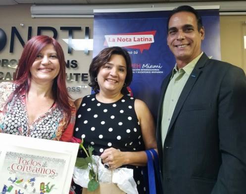 Albert Collazos, director de comunicaciones Hispanas de la Ford, entrega reconocimiento a Patricia Rebellón, por "El Palo de Mamoncillos", mejor su cuento ambientalista.