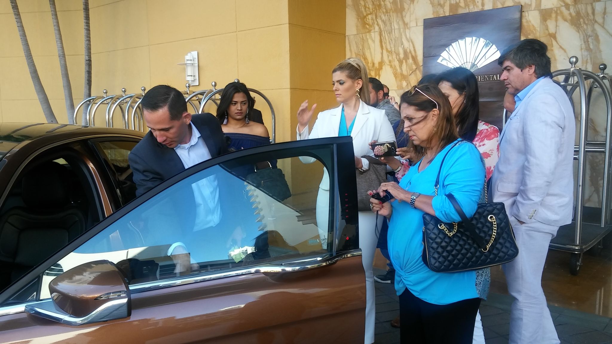 Un grupo de comunicadores de Miami reciben intrucciones antes de realizar la prueba de manejo