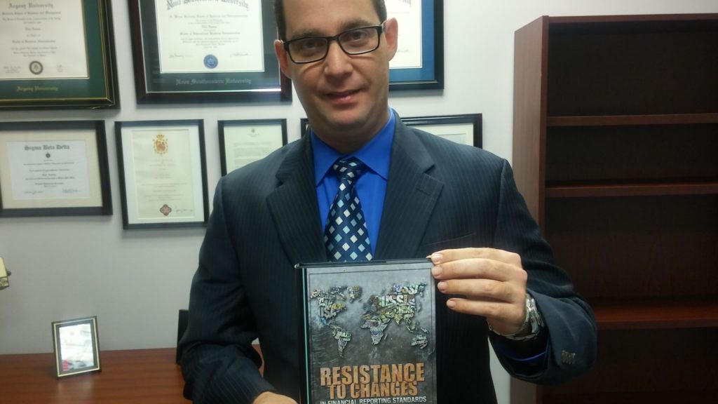 El doctor Edel Lemus muestra su libro" "Resistence to Changes"