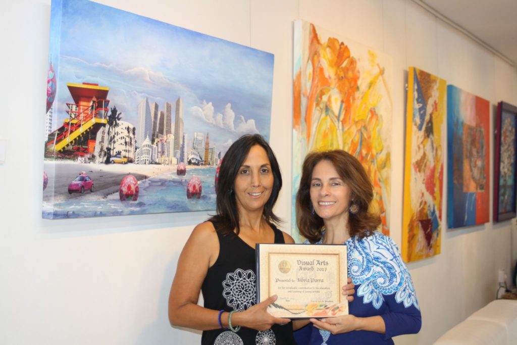 Maritza Salcedo, presidenta de Almenar Otero Foundation, hace entrega del galardon a la artista Silvia Parra.